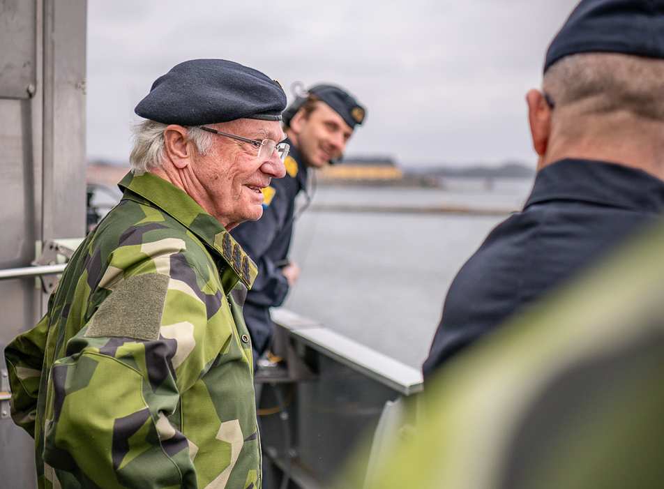 Крал Карл XVI Густаф в униформа с фуражка, заснет в близък план на палубата на кораб в Карлскруна.