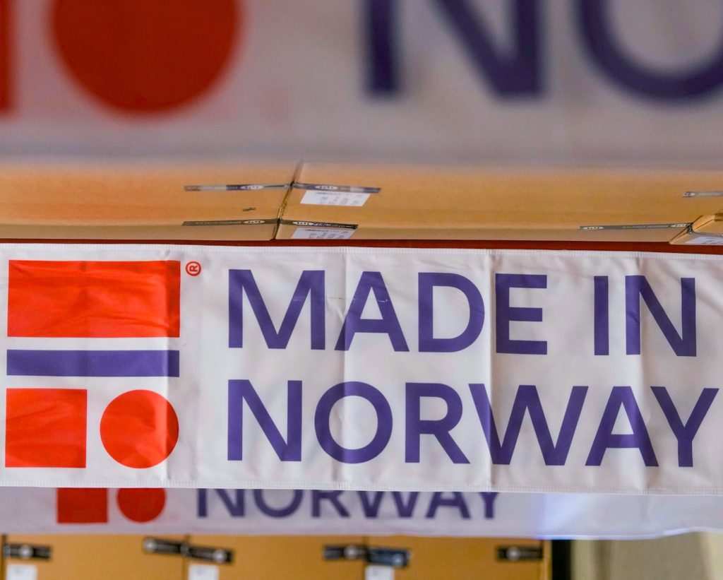 Банер с надпис „MADE IN NORWAY“ и графично лого в червено, бяло и синьо.