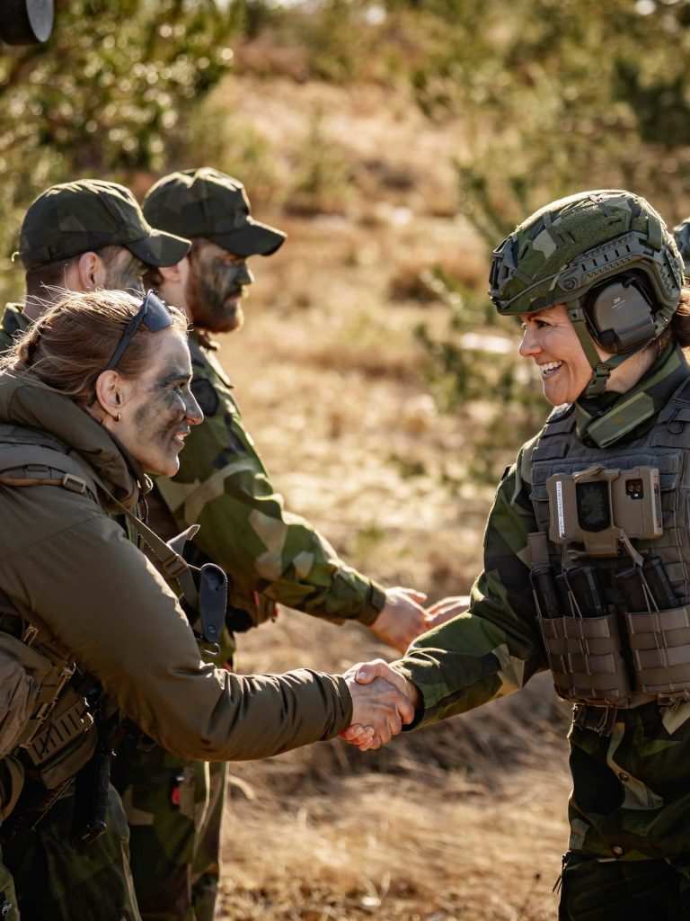 Принцеса Виктория в пълна военна екипировка поздравява жена от латвийската армия.