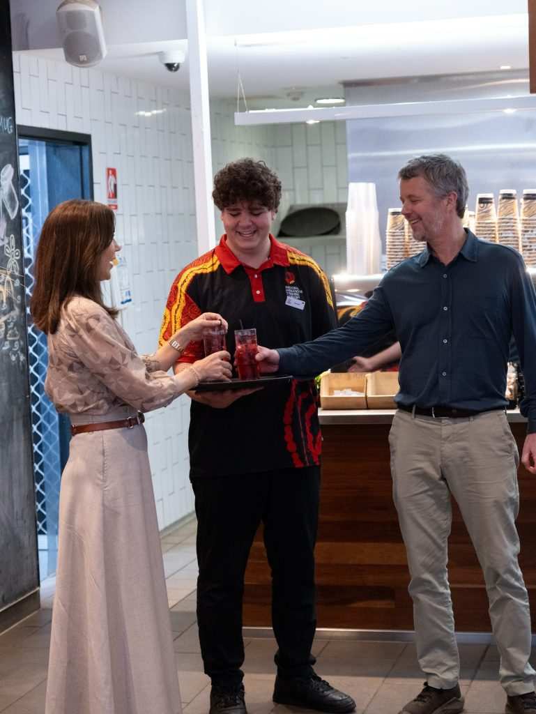 Кралица Мери и крал Фредерик разговарят с млад студент в Kulata Academy Café по време на посещението им в Улуру.