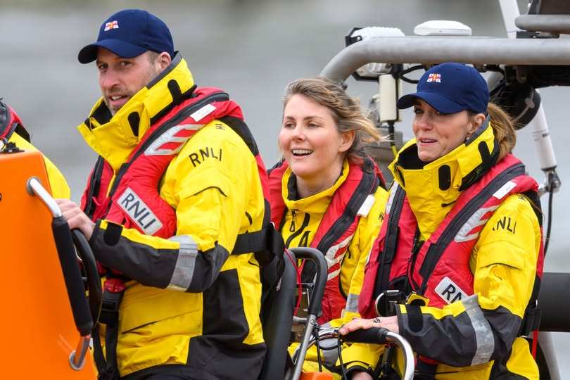 Принцът и принцесата на Уелс в спасителна лодка с жилетки на RNLI.