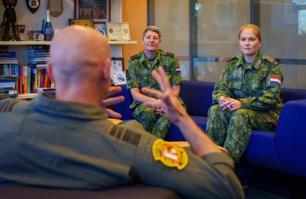 Принцесата в камуфлажна униформа слуша обяснения от ръководител.