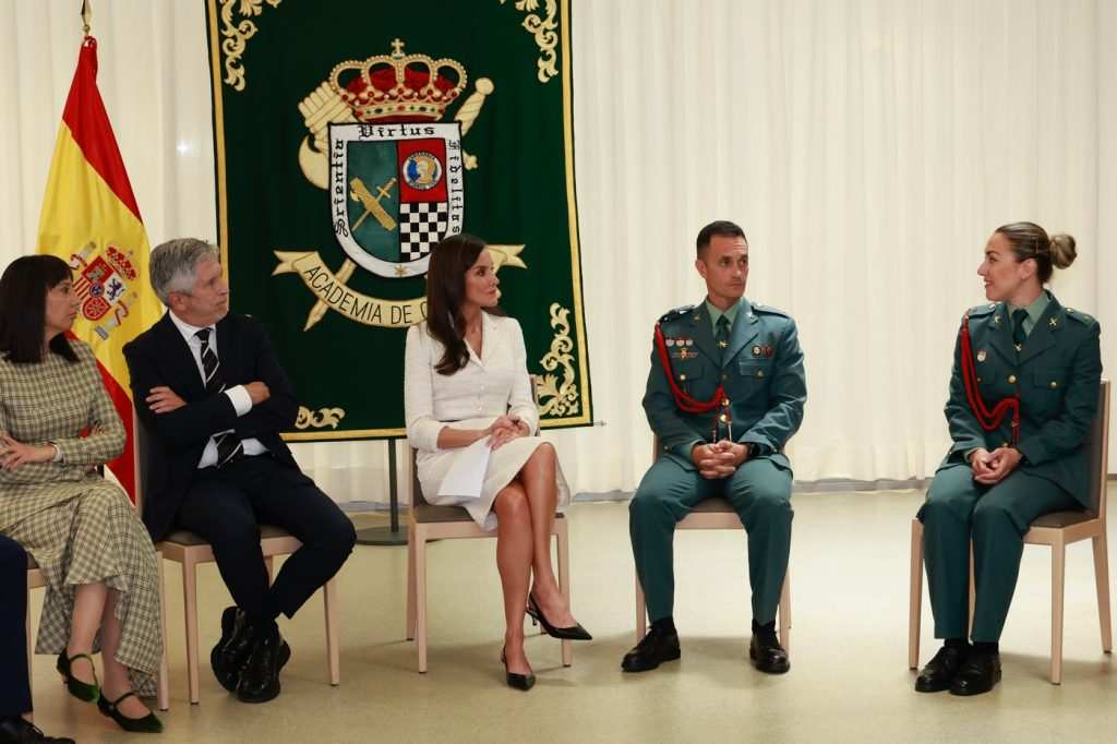 Група хора разговарят в официална зала.