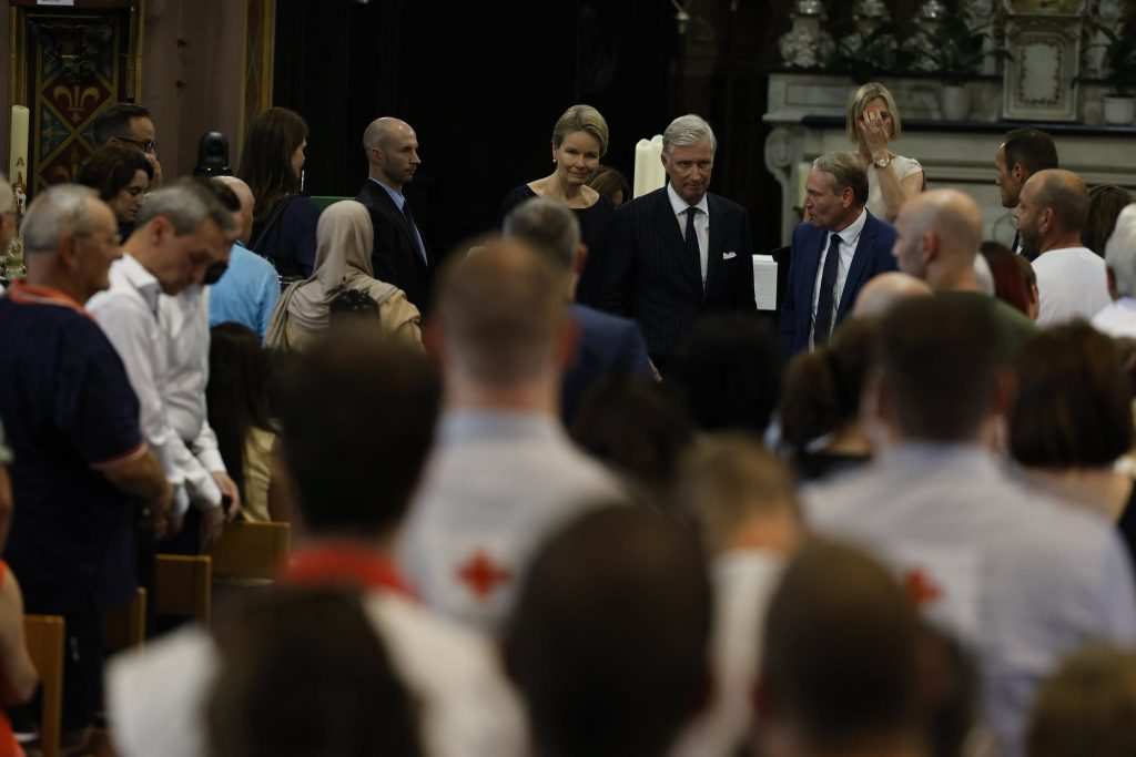 Мъж и жена в тъмни дрехи влизат в църква.