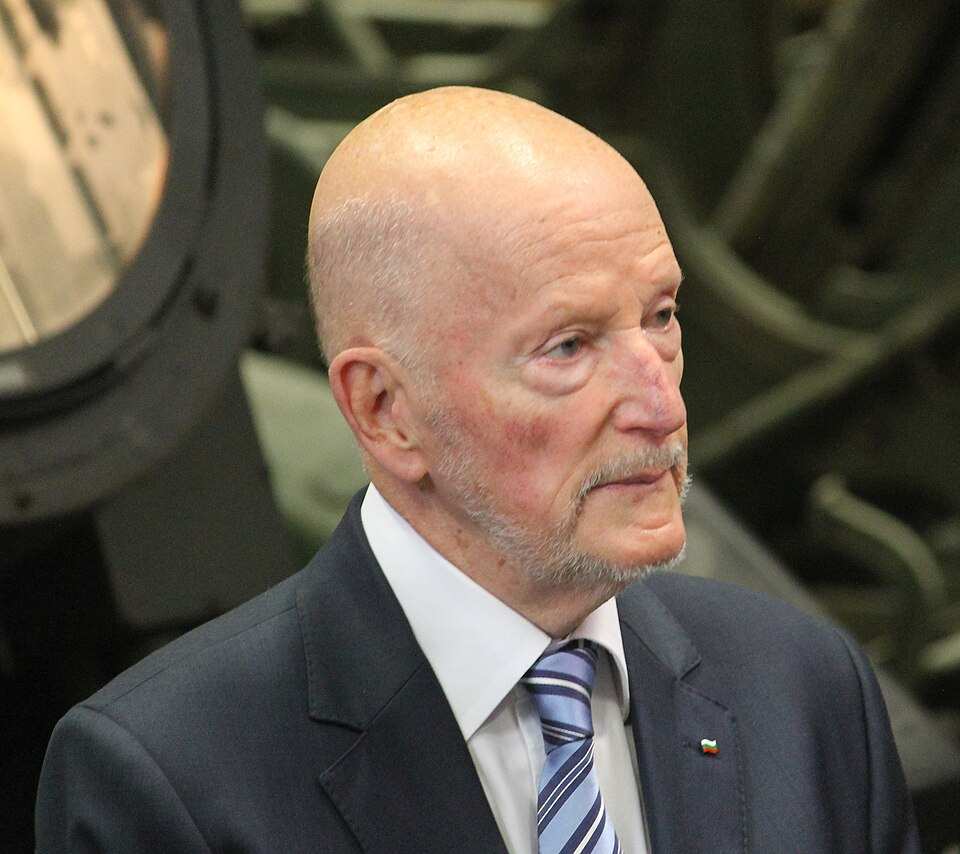 Официална снимка на Симеон с костюм и български флаг на ревера.