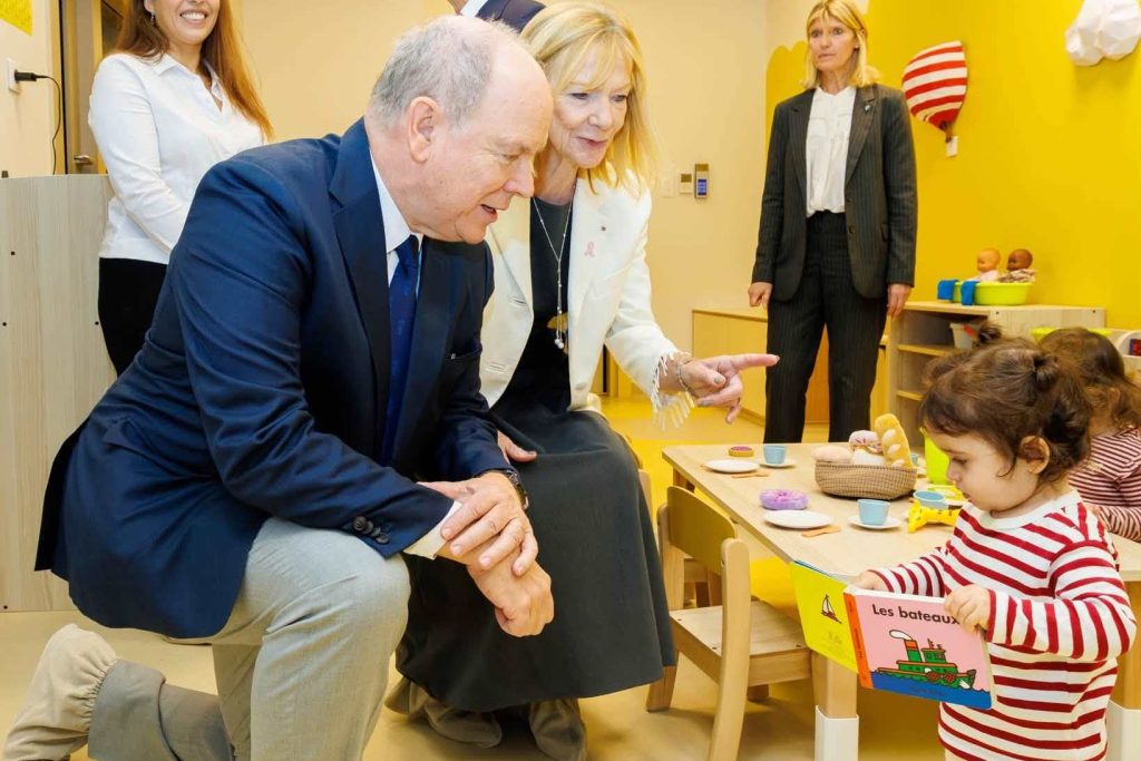 Принц Албер II приклекнал до момиченце с книжка в яслата „Ида“ в Монако
